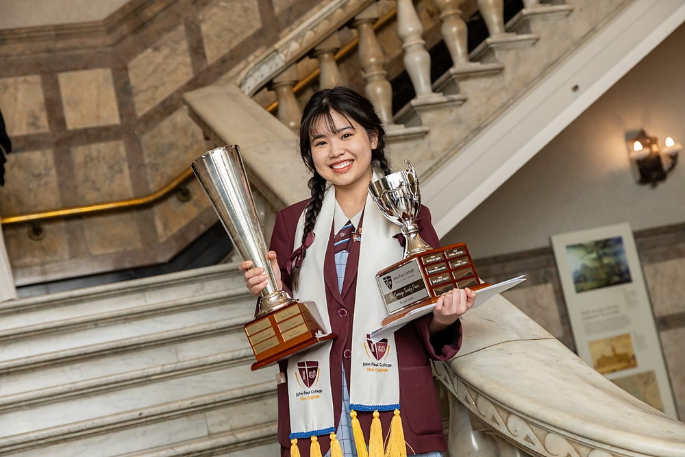 JPC alumna Sam To (Tô Huệ Anh), College Vice Captain, holding the Cameron Cup and the Dennings Family Prize for Legal Studies