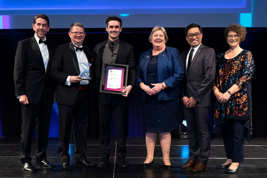John Paul International College accepts the 2022 Premier of Queensland's Export Award for International Education and Training on stage