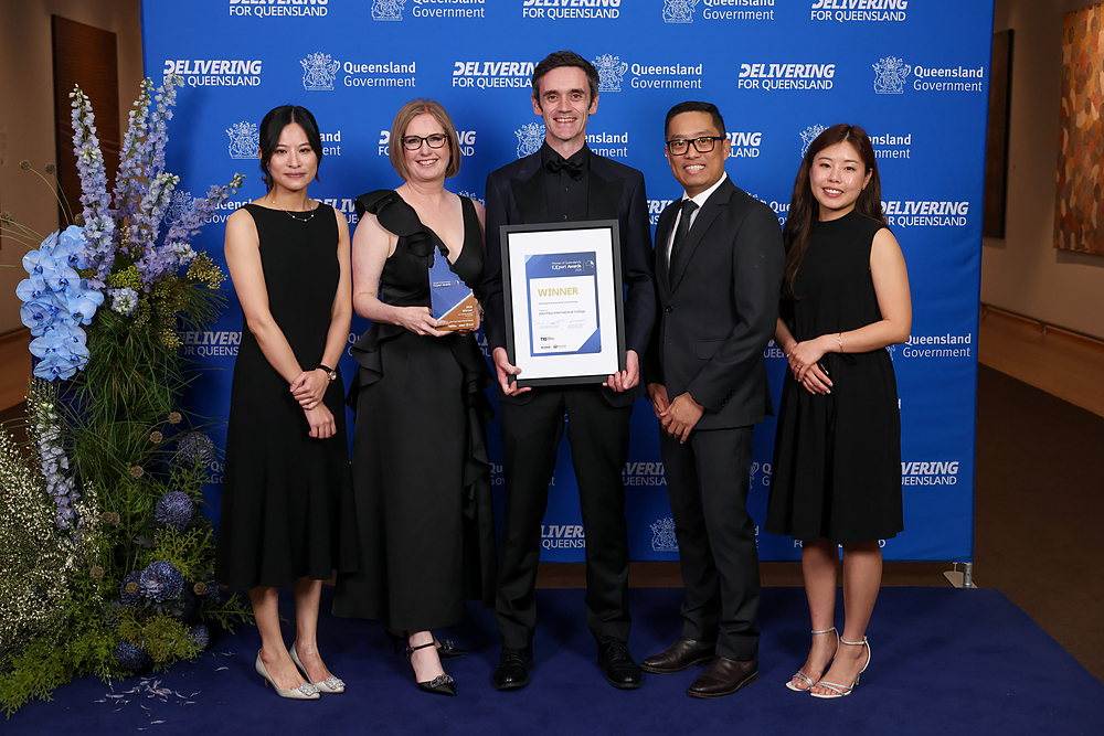 The John Paul College International team with the 2026 winner trophy and certificate