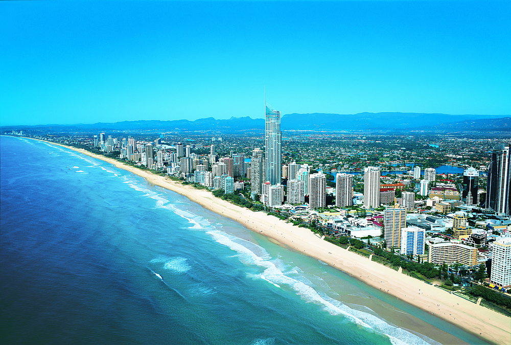 Aerial view of a long sandy beach and coastal towers on the Gold Coast, an hour south of Brisbane