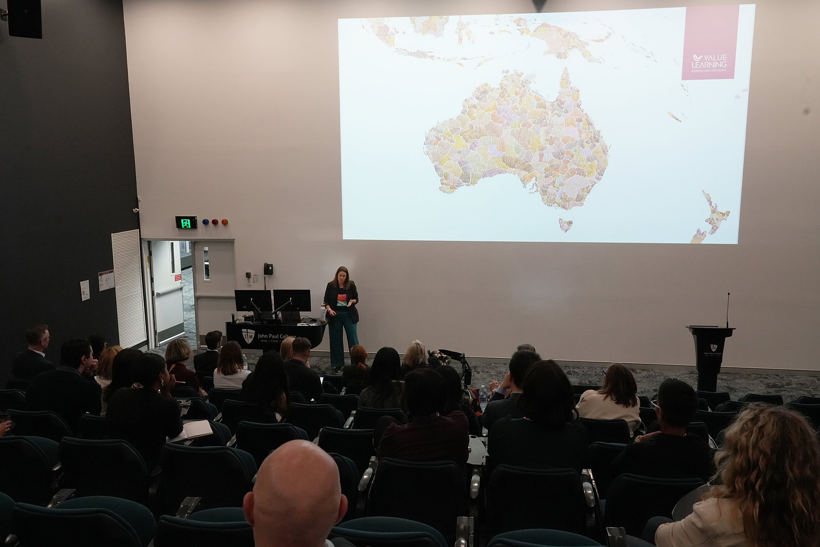 A Value Learning session in the lecture theatre at the School Preparation Conference 2026, with a map of Australia on screen and delegates seated in tiered rows