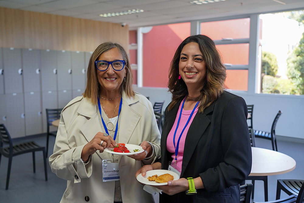 Two delegates smile together during a break at the conference