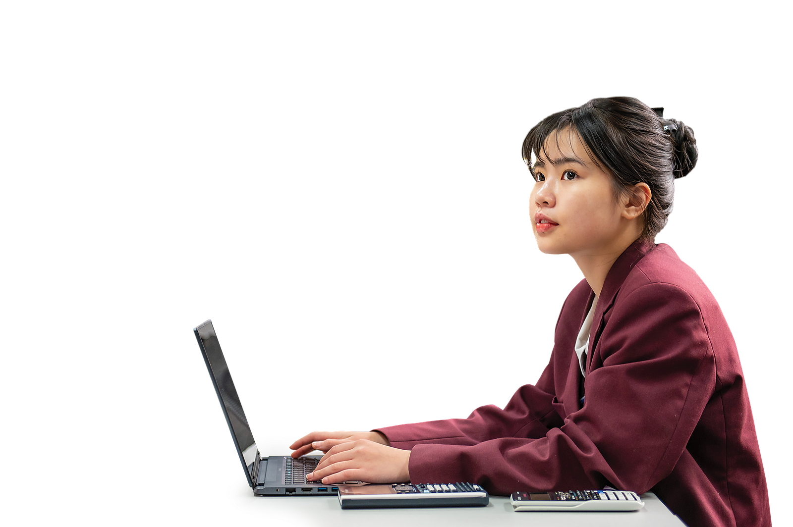 Sam To, a JPIC student, working at a laptop and thinking about her English skills