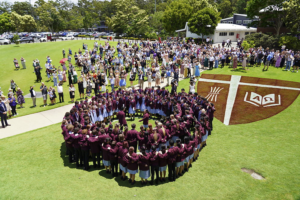 John Paul College Year 12 students gathered around the College crest