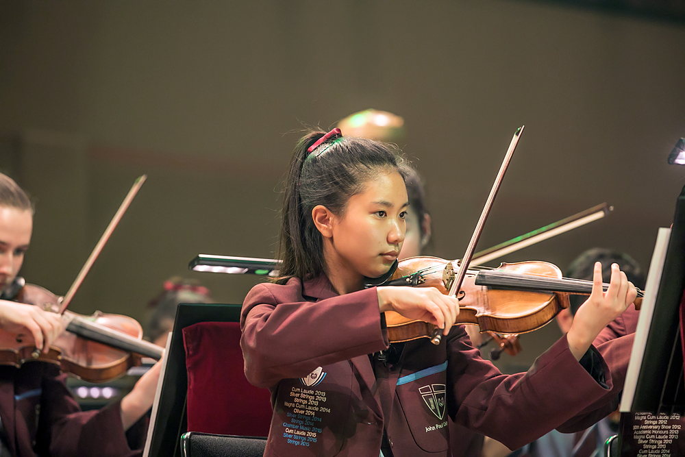 A student playing the violin in a music lesson