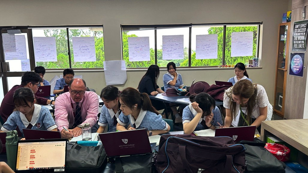 John Paul College students studying with a teacher in a supervised study session