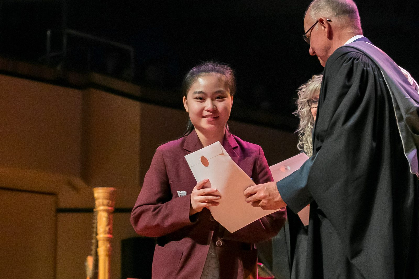 Jessica Le receiving her award on stage at a John Paul College Speech Night