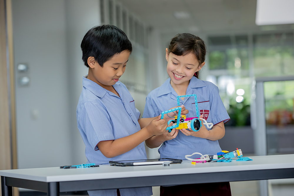 Two primary students building a robotics model together at a STEM club