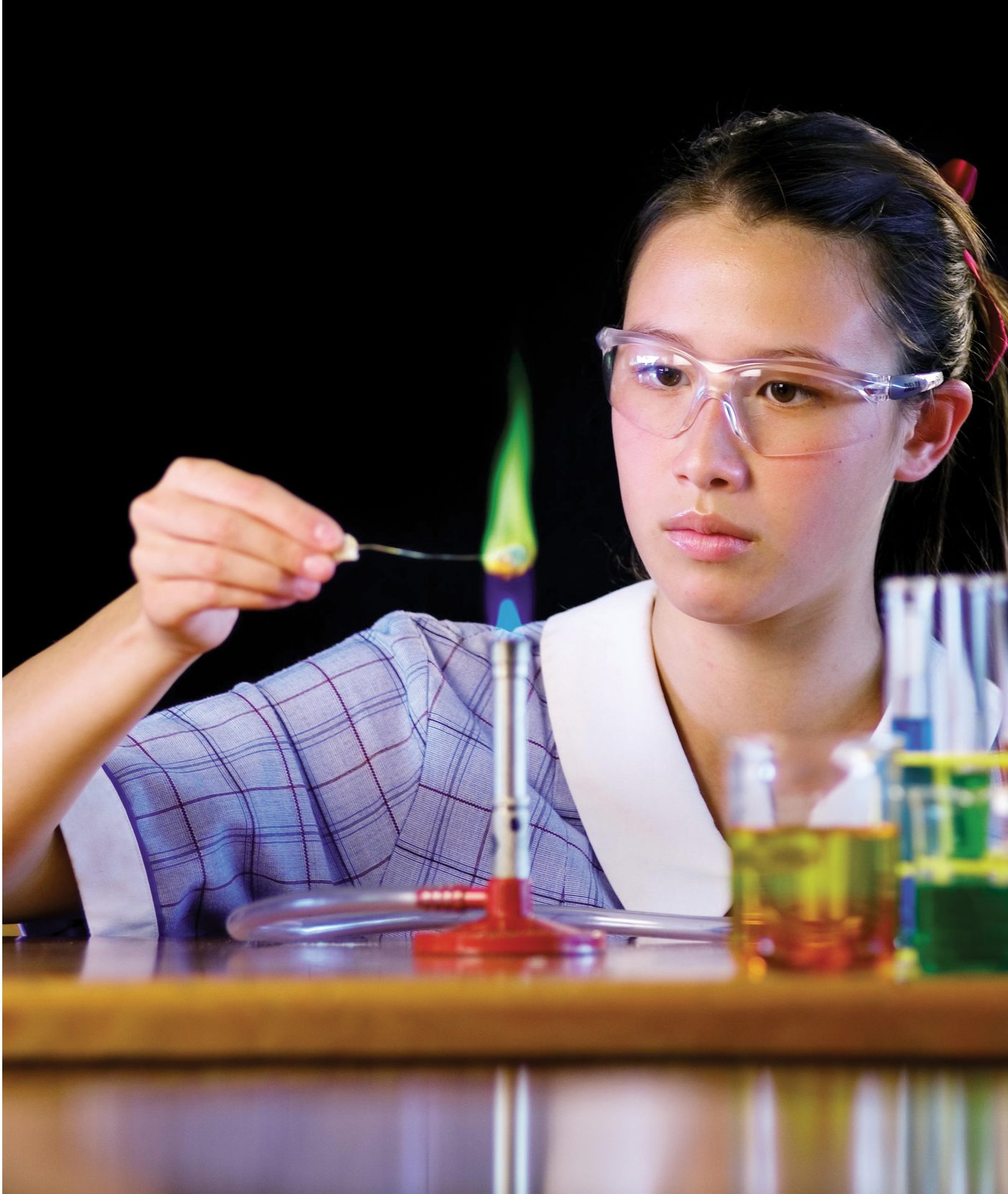 A JPC senior secondary student conducting a flame test experiment in the science laboratory