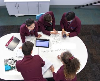 International students and a JPC staff member reviewing paperwork together