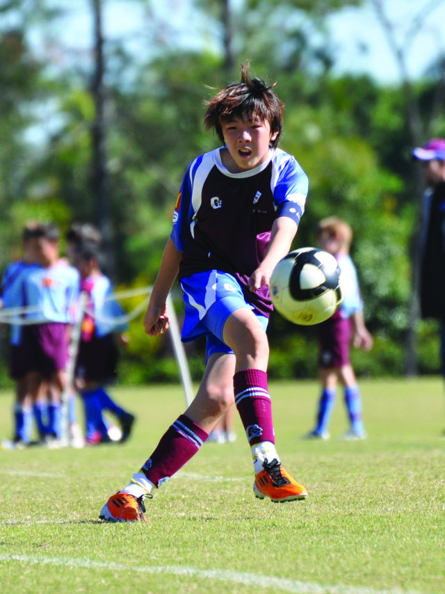 John Paul College students playing football together on the campus oval