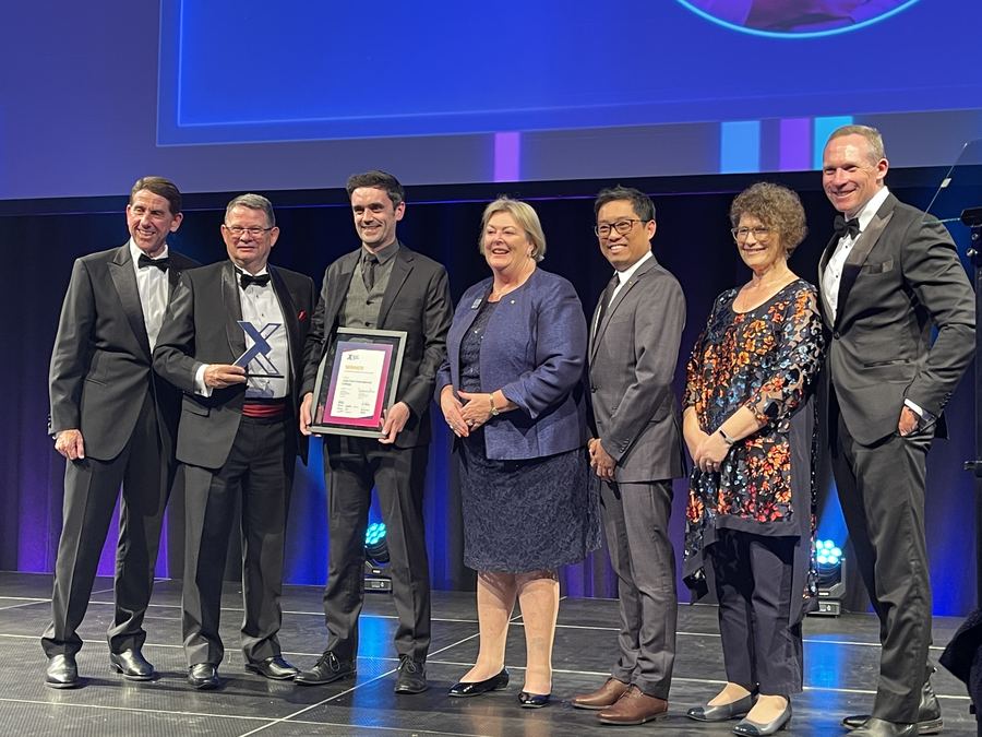 JPIC on stage accepting the 2022 International Education and Training Award