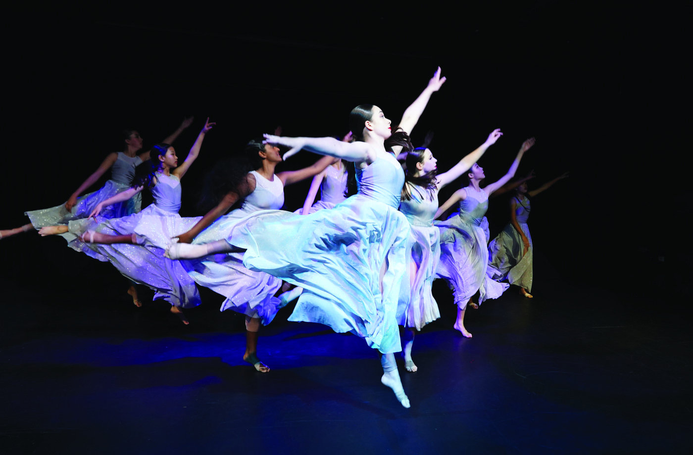 John Paul College students performing in a dance production on stage