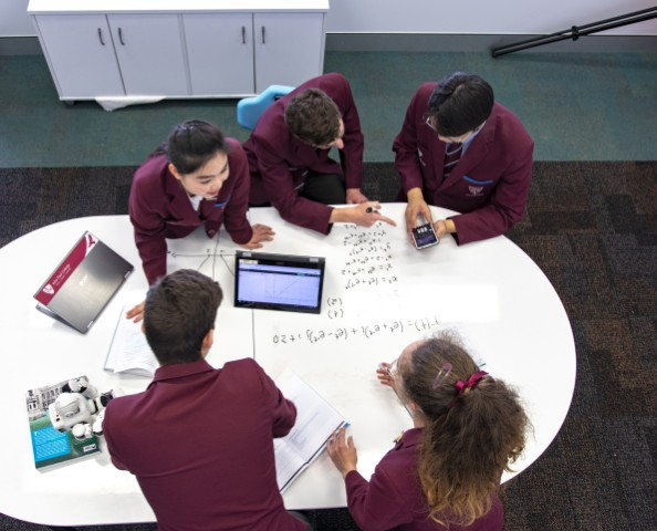 Students working and talking together around a study table